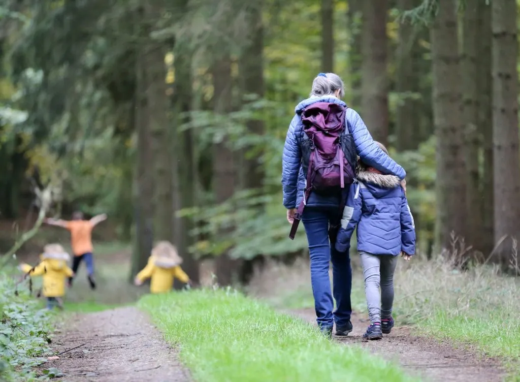 mom and girl walking in woods backpack juliane liebermann Pw7i YVg5uM unsplash
